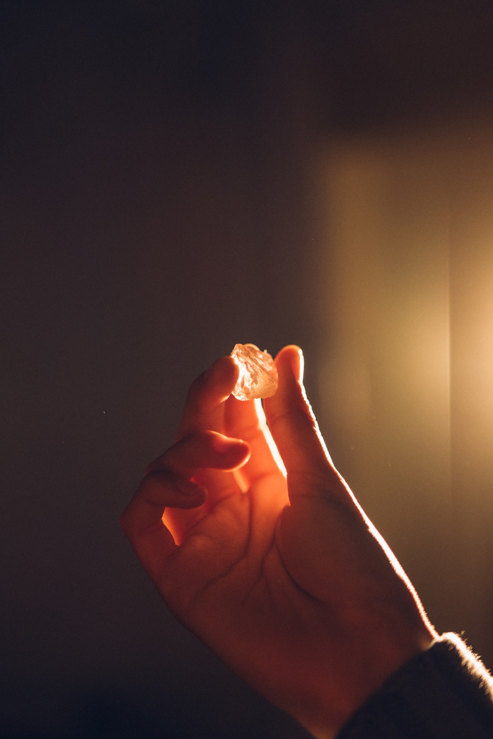 Woman's hand holding a crystal in the light